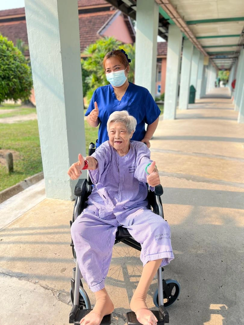 MCS staff member supporting an older person outdoors